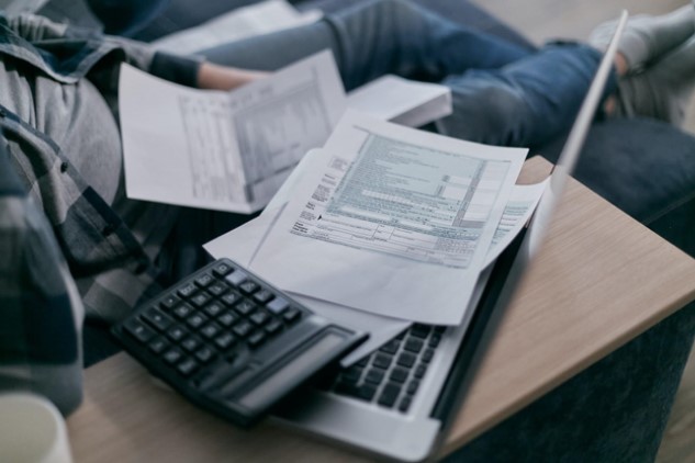 Man sitting with paperwork and calculator